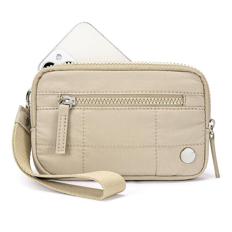 Beige waterproof quilted handbag for women with front zipper pocket and wrist strap, perfect for carrying tech gadgets and daily essentials.